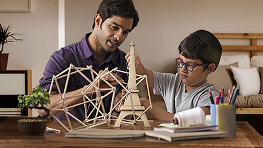 Father and son making wooden Eiffel Tower; image used for HSBC Mauritius Foreign Currency Term deposit page