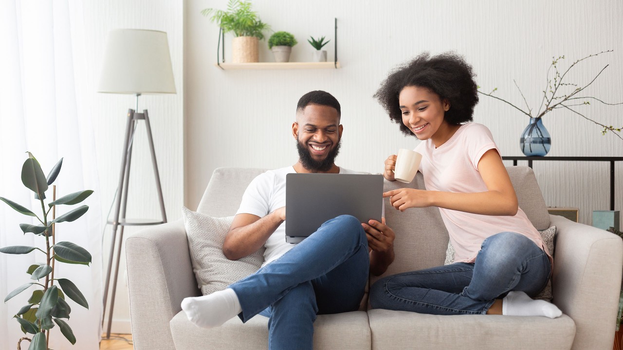 A couple using online banking on sofa; image used for HSBC Mauritius Local Instant Payment Page 